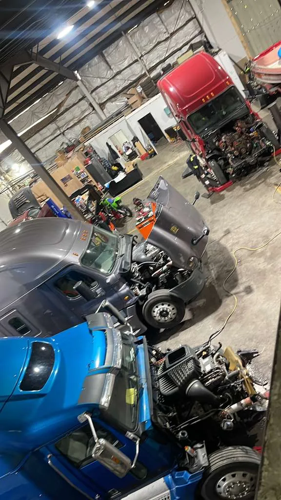 Diesel HP Solutions shop bay with multiple semi-trucks under repair